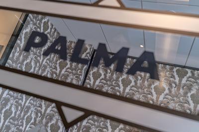 Deux personnes discutent dans une salle de réunion moderne avec écran mural et mobilier haut.