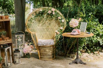 Chambre lumineuse avec lit double, commode en bois, portant à vêtements, télévision et poutre apparente au plafond.