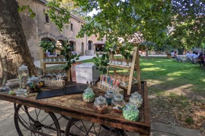 Chambre lumineuse avec lit double, commode en bois, portant à vêtements, télévision et poutre apparente au plafond.