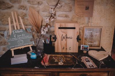Chambre lumineuse avec lit double, commode en bois, portant à vêtements, télévision et poutre apparente au plafond.