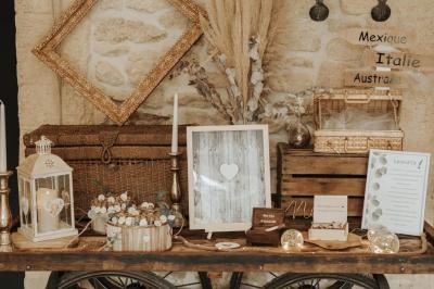 Chambre lumineuse avec lit double, commode en bois, portant à vêtements, télévision et poutre apparente au plafond.