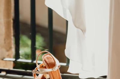 Chambre lumineuse avec lit double, commode en bois, portant à vêtements, télévision et poutre apparente au plafond.