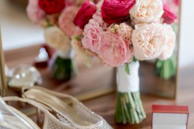 Chambre lumineuse avec lit double, commode en bois, portant à vêtements, télévision et poutre apparente au plafond.