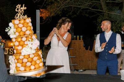Chambre lumineuse avec lit double, commode en bois, portant à vêtements, télévision et poutre apparente au plafond.