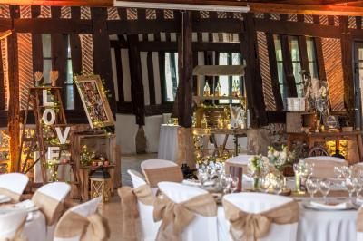 Décoration de salle avec échelle en bois ornée de lettres ’LOVE’, pampas et vases, éclairage violet en arrière-plan.