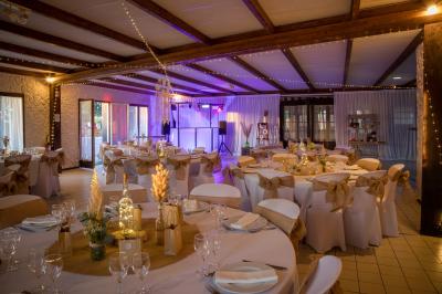 Décoration de salle avec échelle en bois ornée de lettres ’LOVE’, pampas et vases, éclairage violet en arrière-plan.