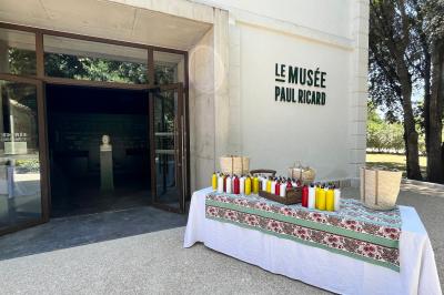 Grande salle vide avec un sol en pierre, plafond en bois avec poutres apparentes et lustres suspendus, décorée de plantes.