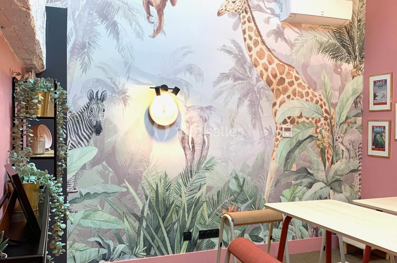 Fresque murale avec animaux sauvages dans une pièce colorée, décorée de plantes et de mobilier moderne.