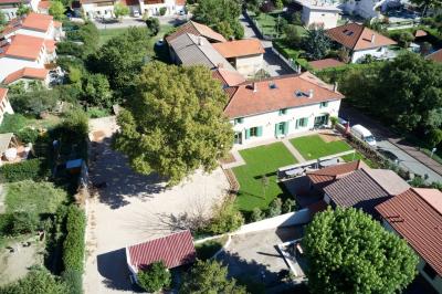 Salle de réunion lumineuse avec murs roses, tables modernes, miroir doré et écran mural.