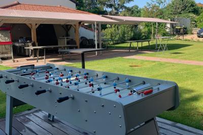 Salle de réunion lumineuse avec murs roses, tables modernes, miroir doré et écran mural.