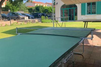 Salle de réunion lumineuse avec murs roses, tables modernes, miroir doré et écran mural.