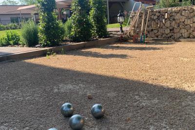 Salle de réunion lumineuse avec murs roses, tables modernes, miroir doré et écran mural.