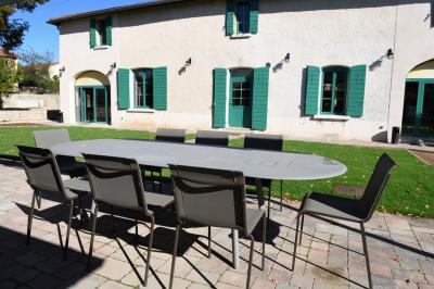Salle de réunion lumineuse avec murs roses, tables modernes, miroir doré et écran mural.