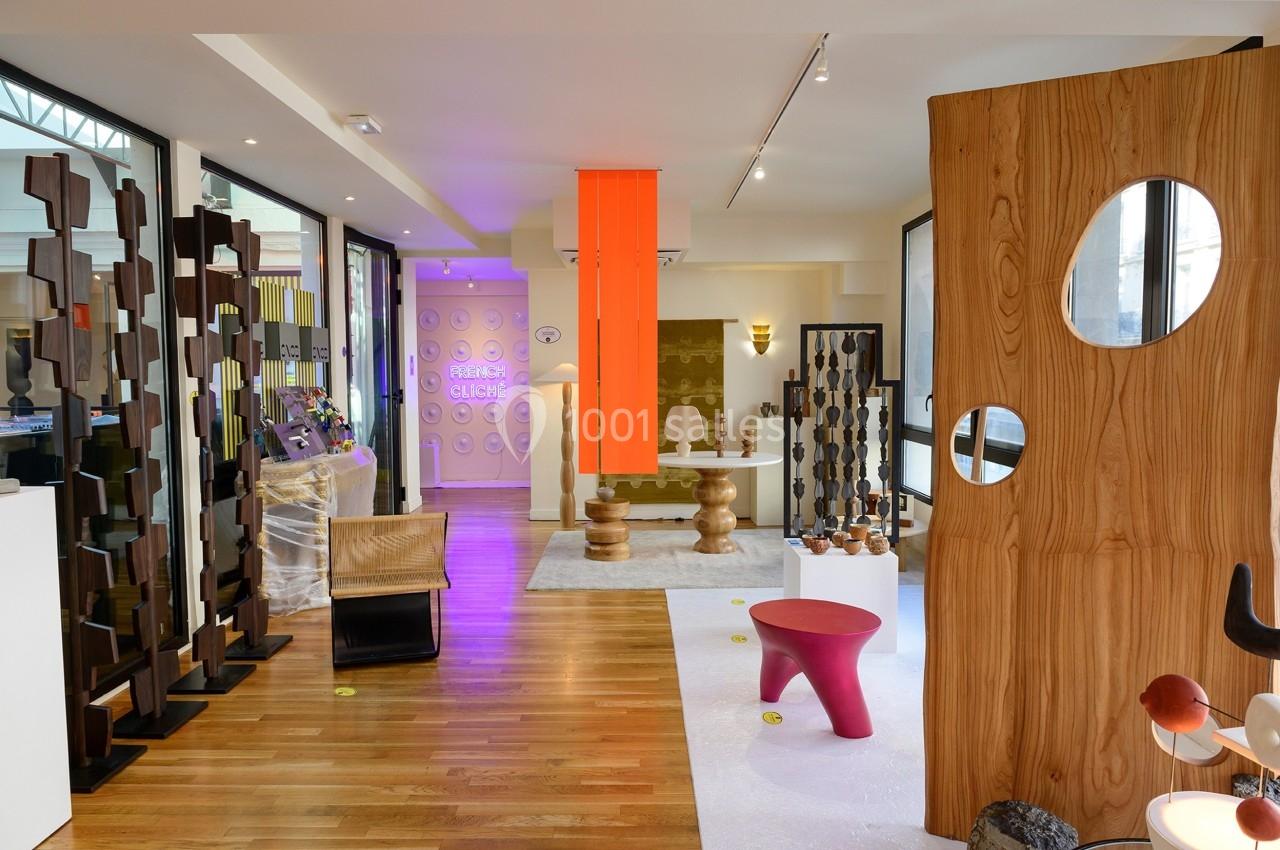 Salle d'exposition moderne avec mobilier design, panneaux en bois sculpté et éclairage coloré.