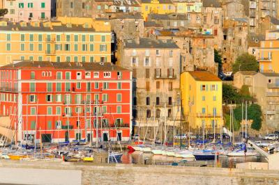 Paysage montagneux au coucher du soleil avec une personne debout sur un promontoire rocheux, entourée de végétation.