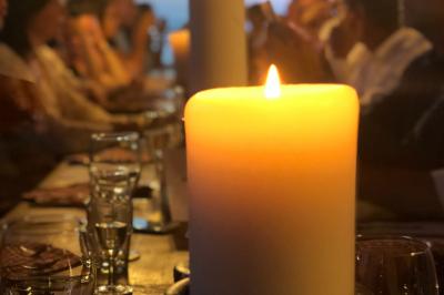 Un bateau pneumatique noir et jaune navigue sur une mer calme, avec une ville et des collines en arrière-plan.