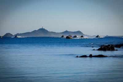 Un homme équipé d'un flyboard s'élève au-dessus de l'eau avec un paysage de collines en arrière-plan.