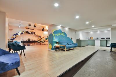 Salle décorée pour une fête avec ballons dorés, noirs et blancs, chiffre ’50’ en ballon et table avec boissons.