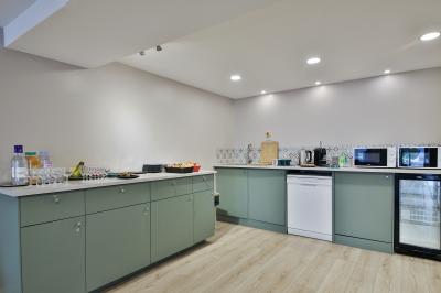 Salle décorée pour une fête avec ballons dorés, noirs et blancs, chiffre ’50’ en ballon et table avec boissons.