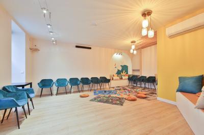 Salle décorée pour une fête avec ballons dorés, noirs et blancs, chiffre ’50’ en ballon et table avec boissons.