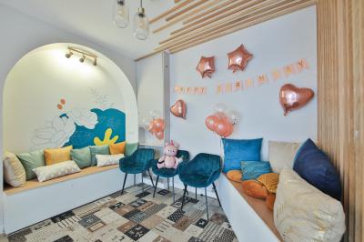 Salle décorée pour une fête avec ballons dorés, noirs et blancs, chiffre ’50’ en ballon et table avec boissons.