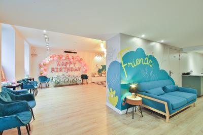 Salle décorée pour une fête avec ballons dorés, noirs et blancs, chiffre ’50’ en ballon et table avec boissons.