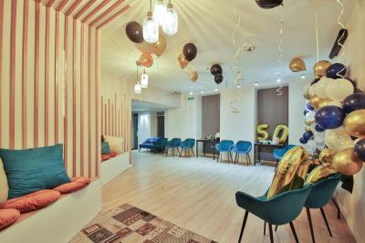 Salle décorée pour une fête avec ballons dorés, noirs et blancs, chiffre ’50’ en ballon et table avec boissons.