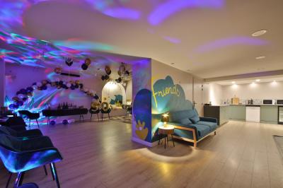 Salle décorée pour une fête avec ballons dorés, noirs et blancs, chiffre ’50’ en ballon et table avec boissons.