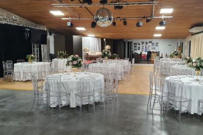 Espace intérieur en bois avec canapés, fauteuils, guirlande lumineuse et stand décoratif éclairé.
