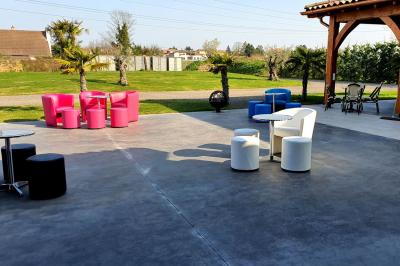 Espace intérieur en bois avec canapés, fauteuils, guirlande lumineuse et stand décoratif éclairé.