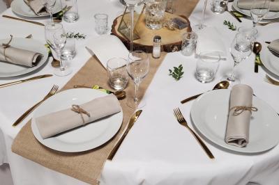 Espace intérieur en bois avec canapés, fauteuils, guirlande lumineuse et stand décoratif éclairé.