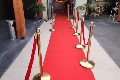 Espace intérieur en bois avec canapés, fauteuils, guirlande lumineuse et stand décoratif éclairé.