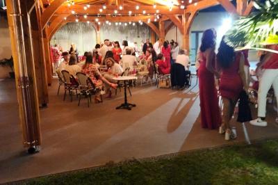 Espace intérieur en bois avec canapés, fauteuils, guirlande lumineuse et stand décoratif éclairé.