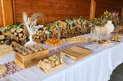 Espace intérieur en bois avec canapés, fauteuils, guirlande lumineuse et stand décoratif éclairé.
