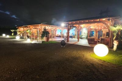 Espace intérieur en bois avec canapés, fauteuils, guirlande lumineuse et stand décoratif éclairé.