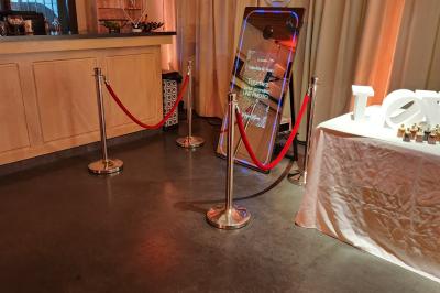 Espace intérieur en bois avec canapés, fauteuils, guirlande lumineuse et stand décoratif éclairé.