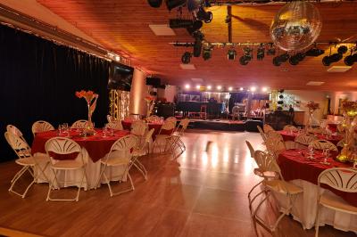 Espace intérieur en bois avec canapés, fauteuils, guirlande lumineuse et stand décoratif éclairé.