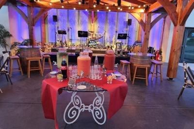 Espace intérieur en bois avec canapés, fauteuils, guirlande lumineuse et stand décoratif éclairé.