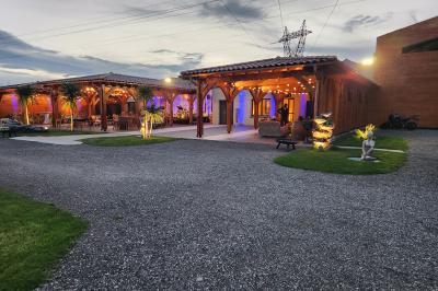 Espace intérieur en bois avec canapés, fauteuils, guirlande lumineuse et stand décoratif éclairé.
