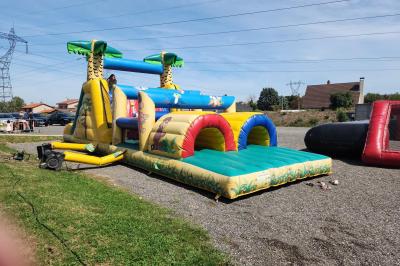 Structure gonflable sur le thème de Spider-Man installée en extérieur, à côté d'une autre structure colorée.