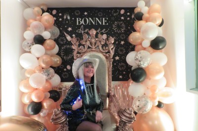 Un groupe de musiciens et chanteurs joue sur une scène éclairée dans une salle avec un public assis.