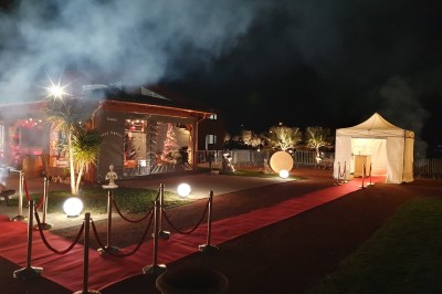 Un groupe de musiciens et chanteurs joue sur une scène éclairée dans une salle avec un public assis.