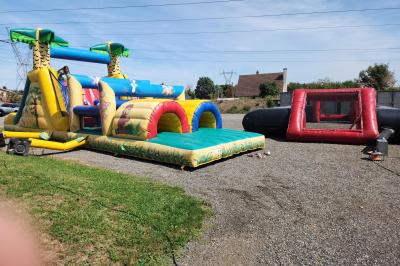 Un groupe de musiciens et chanteurs joue sur une scène éclairée dans une salle avec un public assis.
