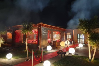 Un groupe de musiciens et chanteurs joue sur une scène éclairée dans une salle avec un public assis.