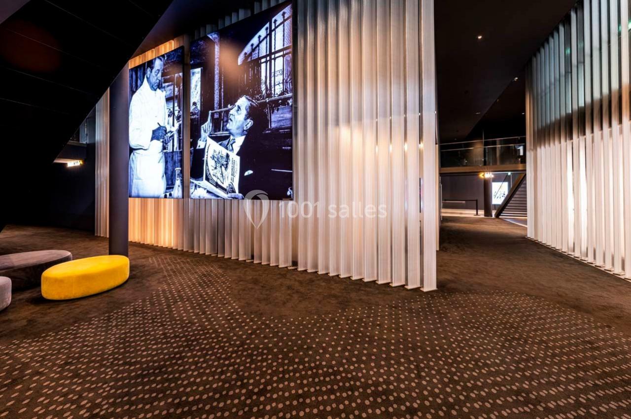 Vue intérieure d'un espace moderne avec un écran affichant une photo en noir et blanc et un sol à motifs.