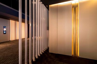 Façade d'un cinéma moderne avec terrasse extérieure équipée de tables hautes et tabourets.