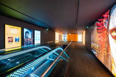 Salle de cinéma moderne avec écran large, sièges rouges et éclairage tamisé, affichant ’Pathé Dijon, Salle 9, 85 fauteuils’.