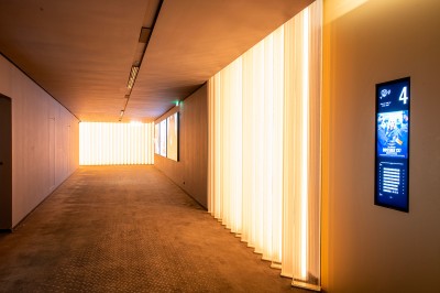 Salle de cinéma moderne avec écran large, sièges rouges et éclairage tamisé, affichant ’Pathé Dijon, Salle 9, 85 fauteuils’.