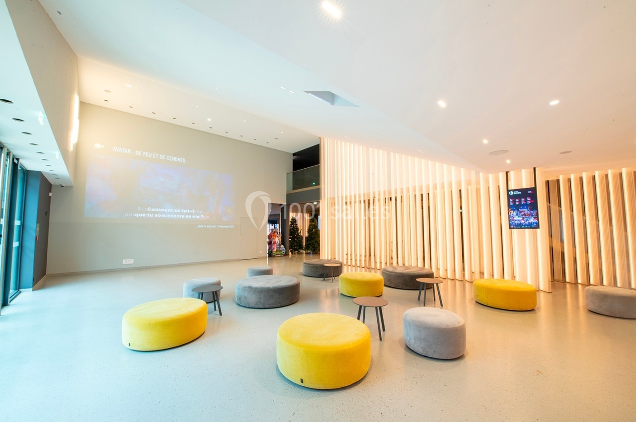 Espace intérieur moderne avec des poufs colorés, un sol clair et des panneaux lumineux en bois.