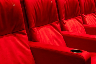 Salle de cinéma moderne avec écran large, sièges rouges et éclairage tamisé, affichant ’Pathé Dijon, Salle 9, 85 fauteuils’.